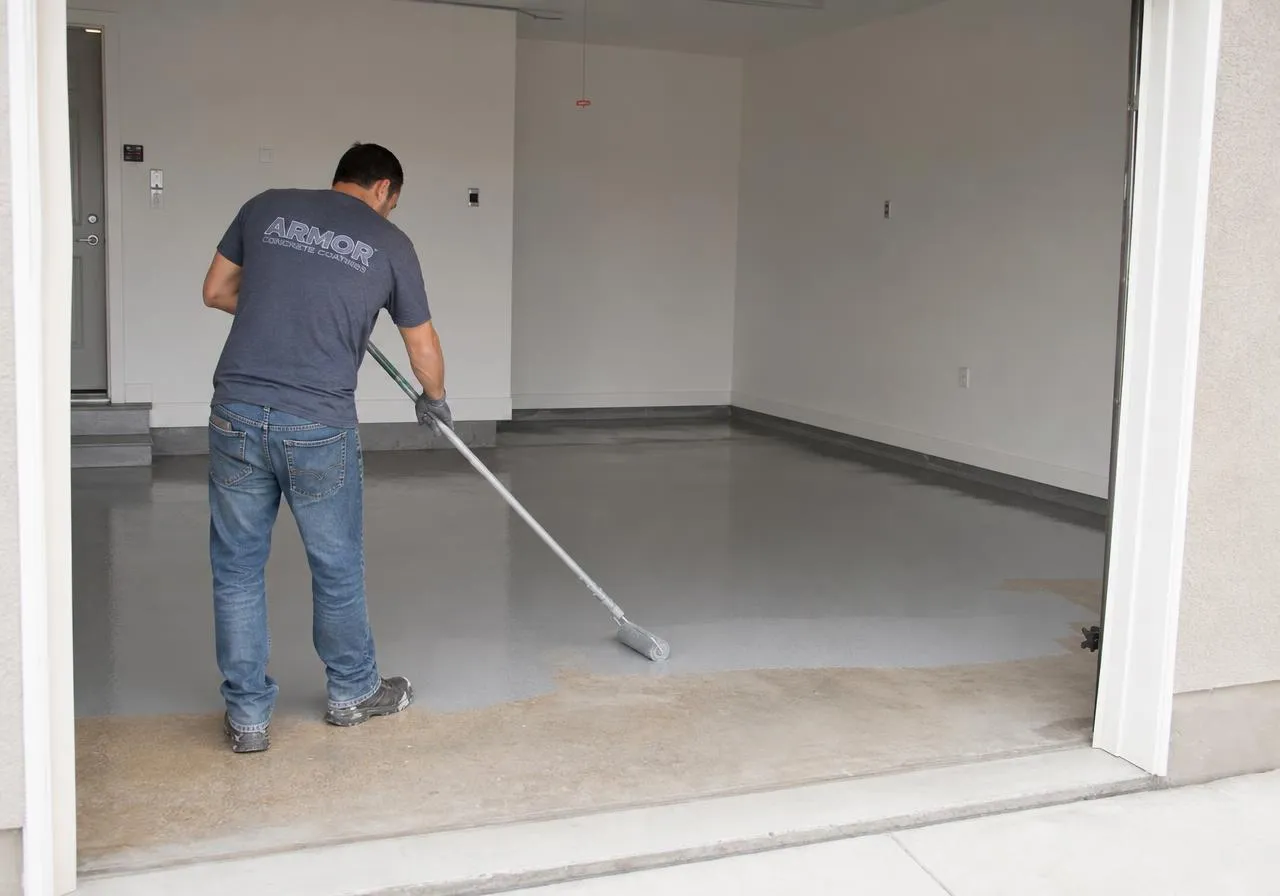 Installer rolling a wet gray polyurea base coat onto a prepared garage floor